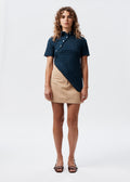 Say the Label Daisy Asymmetric Top in navy with daisy embroidery, worn with a beige skirt