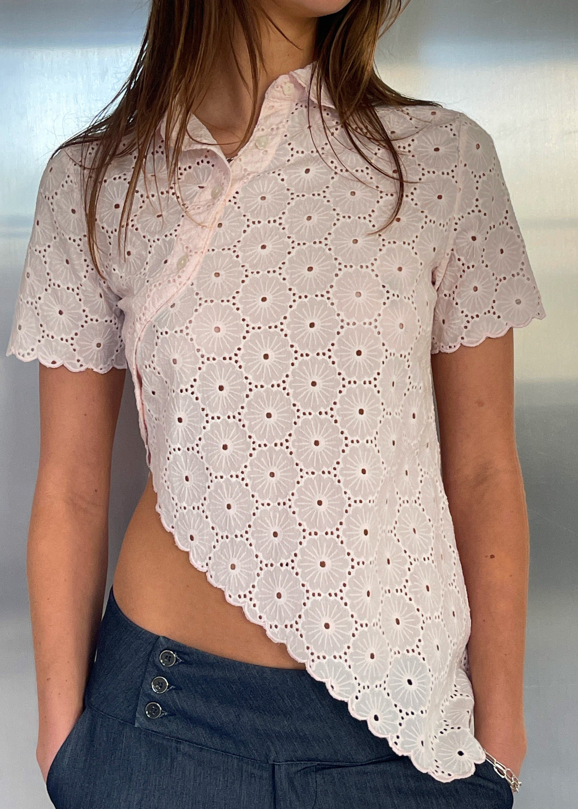 Say the Label Daisy Asymmetric Top in blush pink with daisy embroidery, worn with jeans