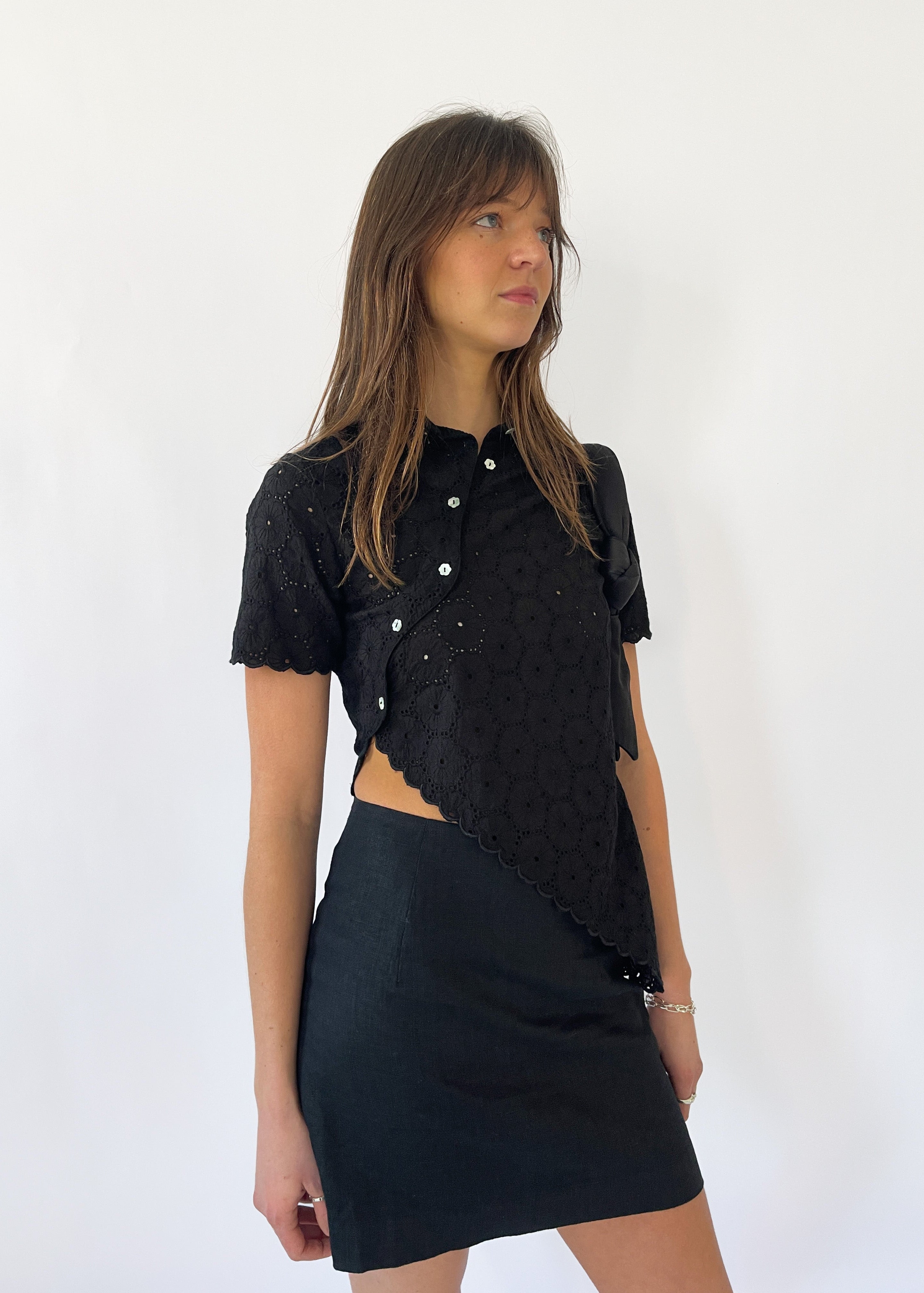Say the Label Daisy Asymmetric Top in noir black with daisy embroidery, worn with a black skirt